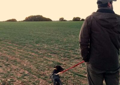 Un cazador y su perro observando el atardecer en ambiente rural